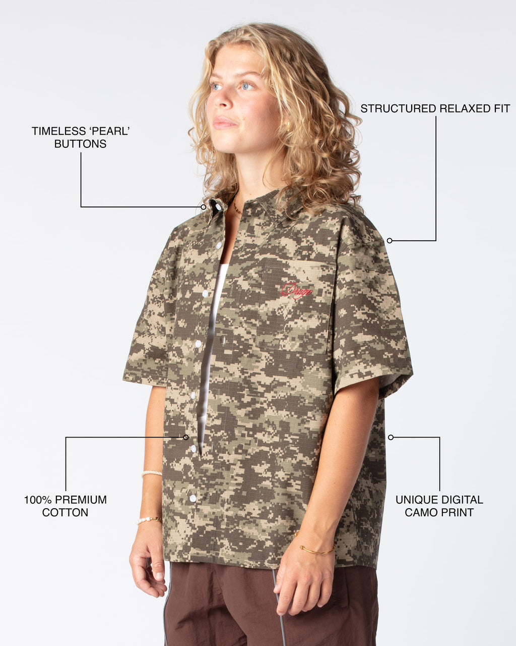 Diagonal view featuring highlights of the script shirt including pearl buttons, relaxed fit, premium cotton material and unique camo print