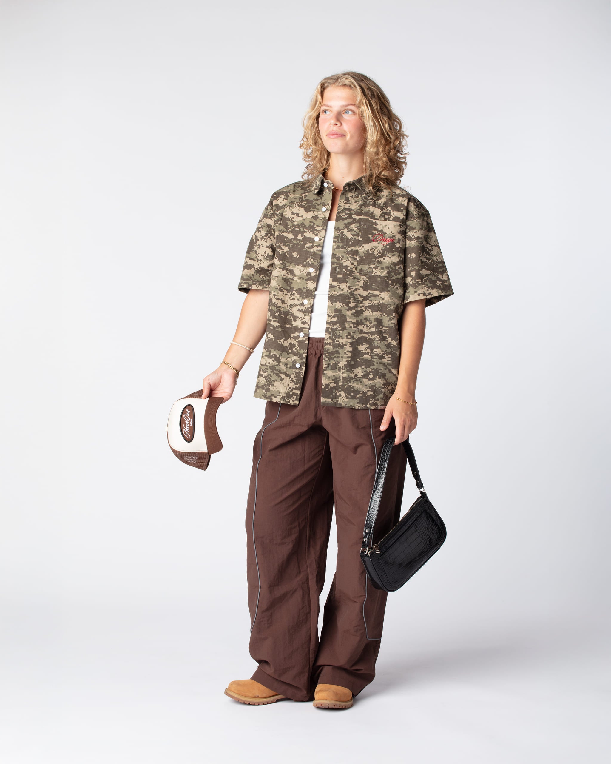 Diagonal Shot of our Track Pants Brown Cacao on body, showing off the signature u-curve reflective piping