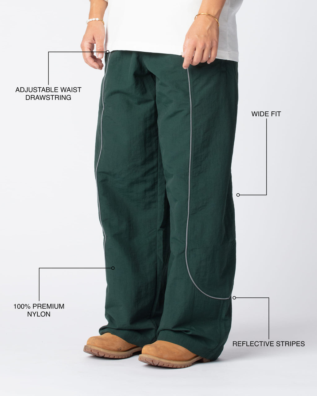 Diagonal Track Pants Olive shot, showing adjustable waist drawstring, wide fit, premium nylon material and signature curved reflective stripes