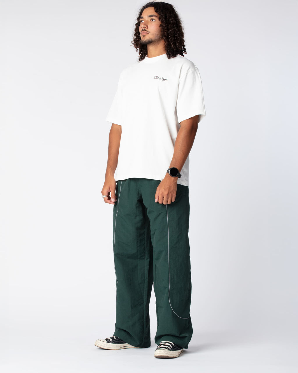 Diagonal Shot of our Track Pants Green Olive on body, showing off the signature u-curve reflective piping