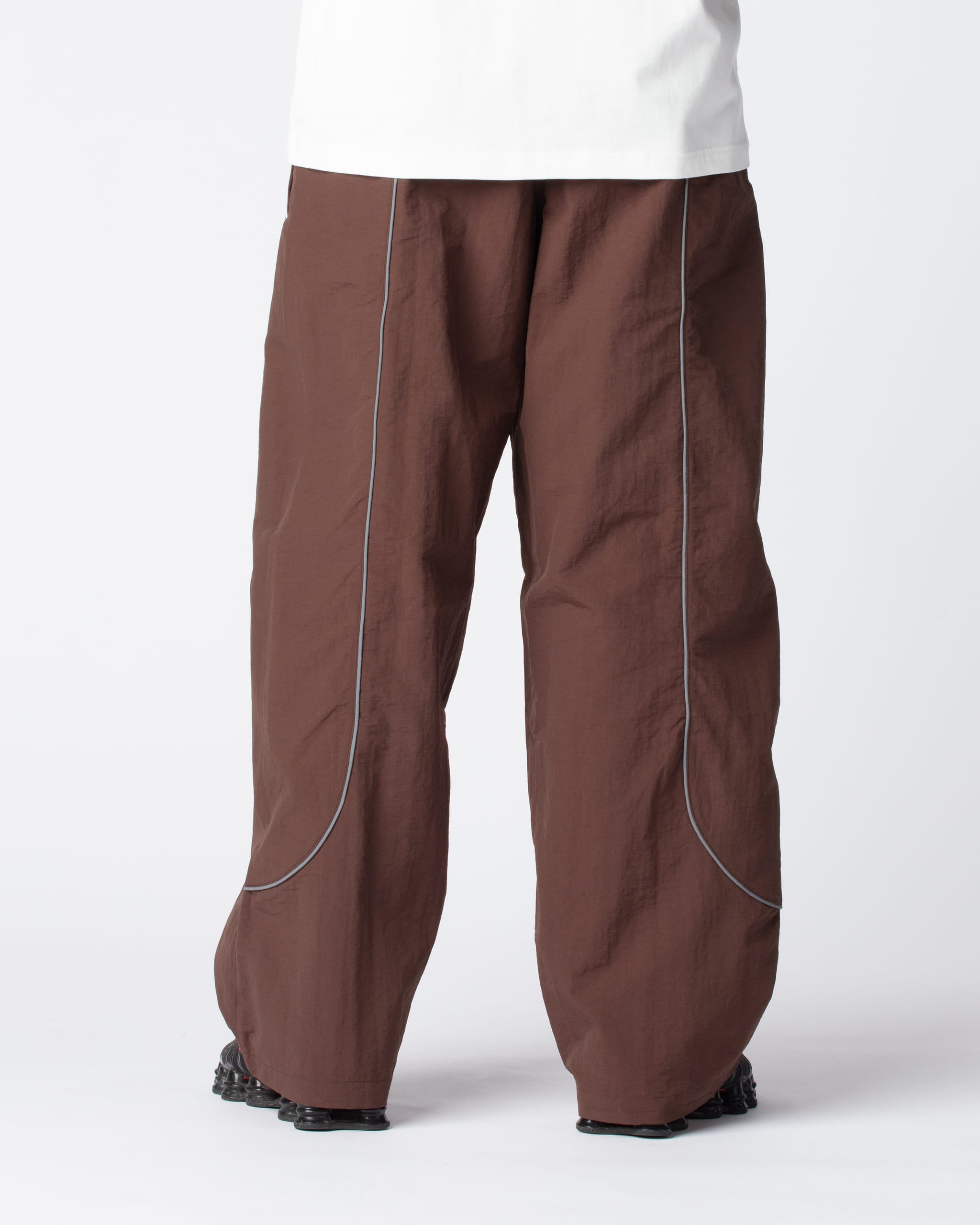 Our Track Pants Brown Cacao from the rear, showing the signature curved reflective stripes and fan favorite wide fit