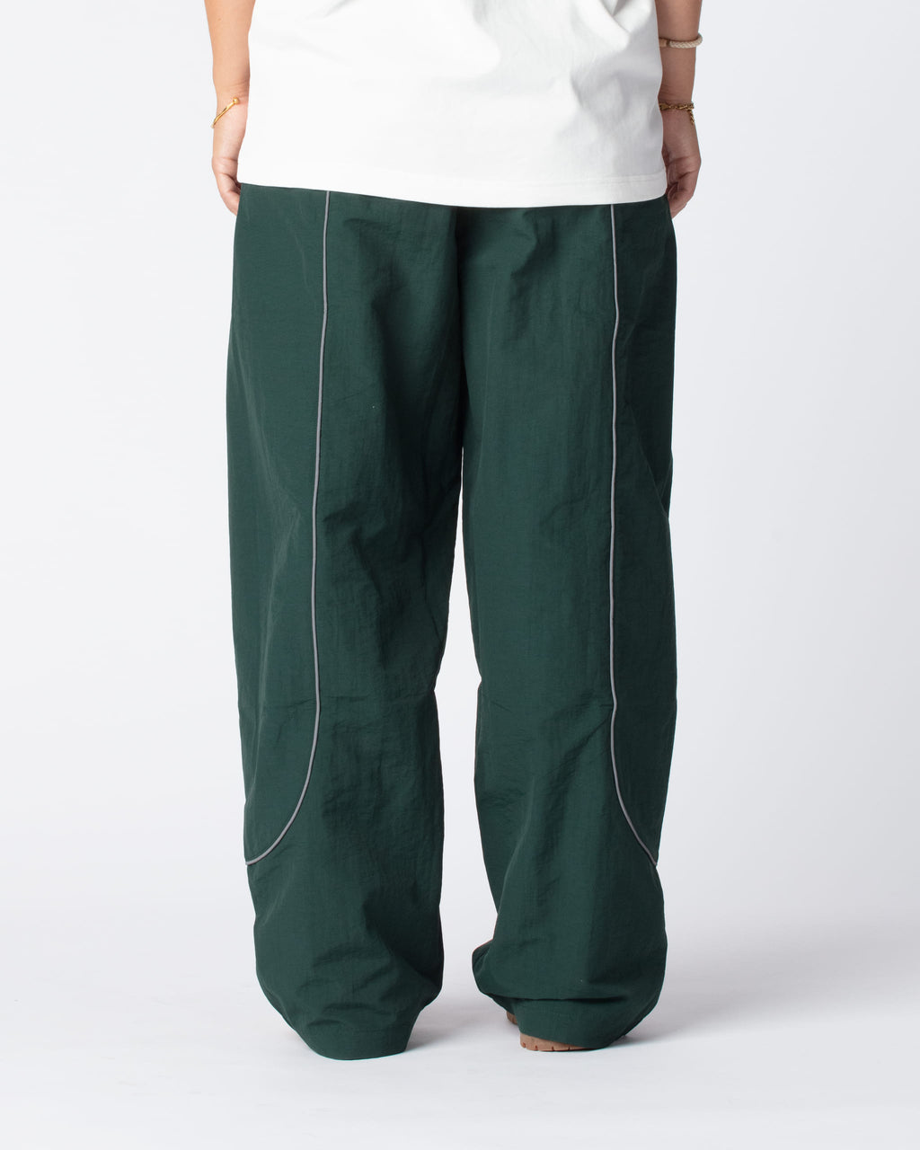 Our Track Pants Olive Green from the rear, showing the signature curved reflective stripes and fan favorite wide fit